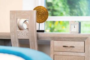 a wooden table with a window with a clock on it at Rosemount Residence - SJA Stays in Aberdeen