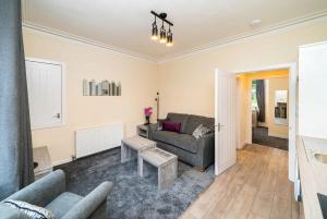 uma sala de estar com um sofá e uma mesa em Rosemount Residence - SJA Stays em Aberdeen