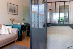 a room with a bed and a couch and a table at RÉF 119 LARMOR-PLAGE Appartement studio moderne in Larmor-Plage