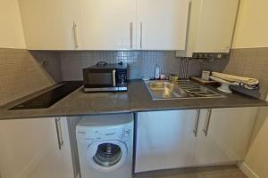 a kitchen with a microwave and a washing machine at RÉF 119 LARMOR-PLAGE Appartement studio moderne in Larmor-Plage