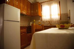 a kitchen with a white refrigerator and a table with a bowl on it at Avlonitis Rooms in Parga