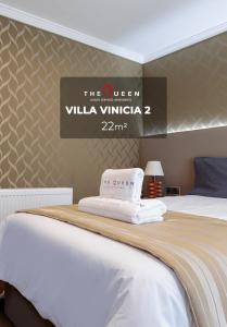 ein Hotelzimmer mit einem Bett mit Schild an der Wand in der Unterkunft The Queen Luxury Apartments - Villa Vinicia in Luxemburg (Stadt)