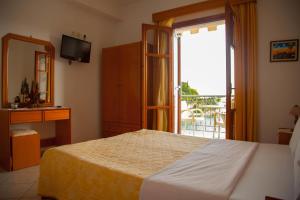 a bedroom with a bed and a window with a balcony at Avlonitis Rooms in Parga