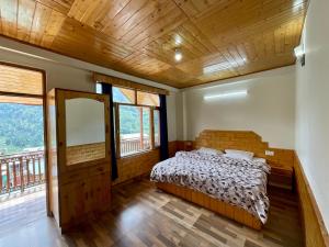 ein Schlafzimmer mit einem Bett in einem Zimmer mit Fenstern in der Unterkunft One Light Stays - Vashisht in Vashisht