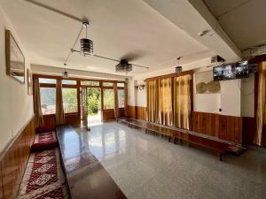 ein leeres Zimmer mit Holzvertäfelung und Glastüren in der Unterkunft One Light Stays - Vashisht in Vashisht