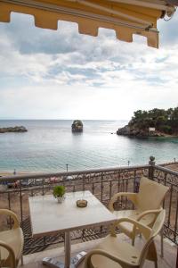 balcón con mesa, sillas y vistas al océano en Avlonitis Rooms, en Parga