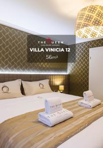 a hotel room with a bed with towels on it at The Queen Luxury Apartments - Villa Vinicia in Luxembourg