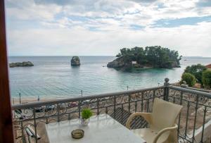 een balkon met een tafel en uitzicht op de oceaan bij Avlonitis Rooms in Parga