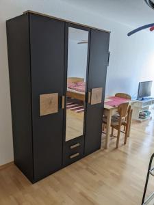 un armario negro con espejo y mesa en Apartment in Ludwigsburg, en Ludwigsburg