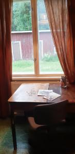 einen Schreibtisch vor einem Fenster mit einem Fenster in der Unterkunft Villa Vintage in Tammela