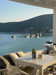 a patio with a table and chairs and boats in the water at Niriedes Hotel in Platis Gialos