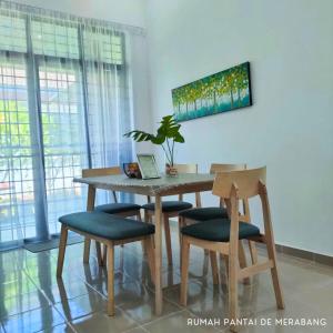 a dining room table and chairs with a plant on it at Rumah Pantai de Merabang (bungalow with pool) in Bachok