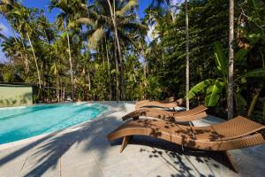 een zwembad met 2 ligstoelen naast een resort bij Oceanature Alibaug in Alibaug