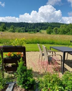 um pátio com uma mesa, cadeiras e flores em Domek Limba em Ustrzyki Dolne