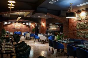 a restaurant with tables and chairs and a brick wall at Gelati Residence in Kutaisi