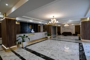 a lobby of a hotel with a man standing at a counter at Gelati Residence in Kutaisi