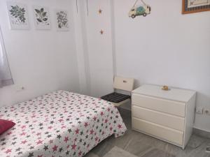 1 dormitorio blanco con 1 cama y vestidor en Islantilla - Bajo con Jardín en Golf Islantilla, en Huelva