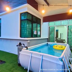 a hot tub in the backyard of a house at Rumah Pantai de Merabang (bungalow with pool) in Bachok