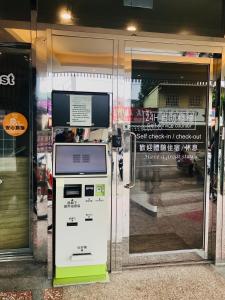 una máquina de venta de entradas frente a una puerta de cristal en 東南亞行旅 en Ta-chia