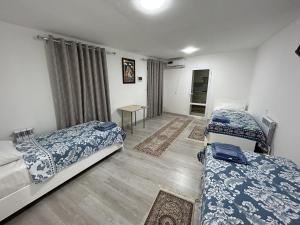a room with two beds and a table in it at "Lime" Aparthotel in Bukhara
