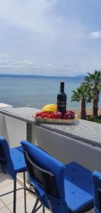 a table with chairs and a bottle of wine and fruit at MARIA'S DREAM HOUSE in Eretria