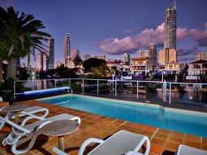 a swimming pool with chairs and a city skyline at Quiet location close to it all in Gold Coast