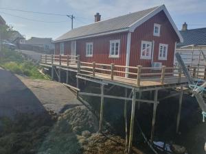 a house on a dock with a building on it at Authentic central located cabin close to Reinebringen Lofoten in Reine