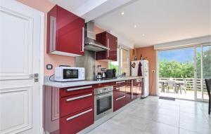 - une cuisine équipée de placards rouges et d'un four micro-ondes dans l'établissement 2 Bedroom Beautiful Apartment In Biot, à Biot