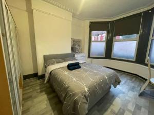 a bedroom with a bed and two windows at Ground Floor 2 Bed Flat with Garden North London in London