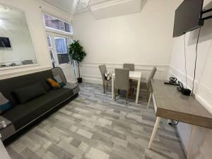 a living room with a couch and a table at Ground Floor 2 Bed Flat with Garden North London in London