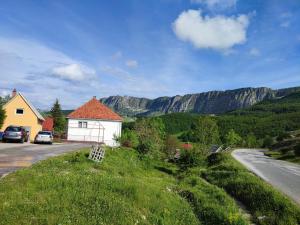 une maison sur le côté d'une route avec des montagnes en arrière-plan dans l'établissement Čemerno Cottage, à Gacko