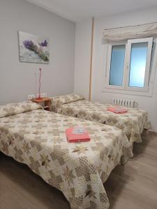 um quarto com duas camas e uma janela em Alojamiento Camiño Real em Sigüeiro