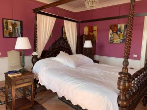 a large bed in a bedroom with purple walls at Palazzo Carratelli in Amantea