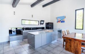 une cuisine avec des appareils en acier inoxydable et une table dans l'établissement Nice Home In Les Adrets-De-L'estére, à Les Adrets-de-l'Estérel