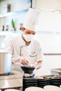 a chef preparing food in a kitchen at Sheraton Nha Trang Hotel & Spa in Nha Trang