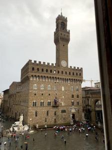 un grande edificio con una torre dell'orologio sopra di New Residenza Dei Cerchi a Firenze