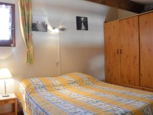 um quarto com uma cama e um armário de madeira em Maison Fleury-Saint-Pierre-la-Mer, 2 pièces, 6 personnes - FR-1-229D-29 em Fleury
