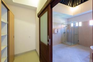 a bathroom with a shower and a glass door at Kubal Villa and Living Seminyak in Canggu