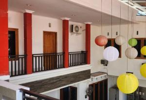 a building with red columns and colorful lights hanging from it at Permata Homestay Kotamobagu Mitra RedDoorz in Poyowa-besar