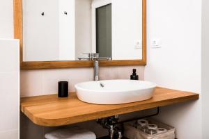 een badkamer met een witte wastafel en een spiegel bij Vina Kobal, Kobal Family Estate in Štanjel