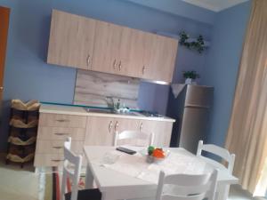 a kitchen with a white table and a refrigerator at Orikum beach in Orikum