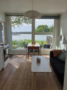 a living room with a table and a large window at Nävekvarns Skärgårdscamping in Nävekvarn
