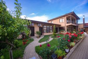 a house with a garden with flowers and plants at Vila Puky in Neptun