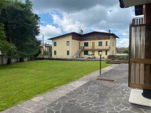 a large house with a grass yard in front of it at Casa Monte Zebio in Asiago