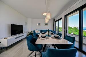 een eetkamer met een tafel en blauwe stoelen bij Apartments Lena in Malinska