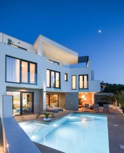 a house with a swimming pool in front of it at Villa Corus in Murter