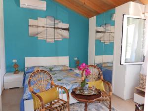 1 Schlafzimmer mit einem Bett, 2 Stühlen und einem Tisch in der Unterkunft Villa Corradina in Floridia