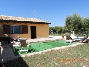 ein Haus mit einem Tisch und Stühlen im Hof in der Unterkunft Villa Corradina in Floridia