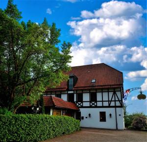 un bâtiment blanc avec un toit rouge dans l'établissement Hotel-Restaurant Zum Landgraf, à Wartmannsroth
