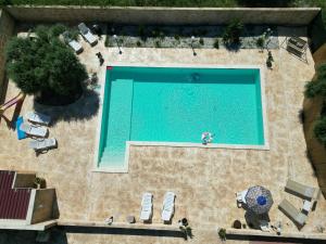 einen Blick über einen großen Pool mit einer Person in einem Badeanzug in in der Unterkunft Villa Corradina in Floridia